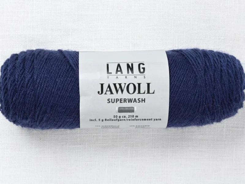 A skein of dark blue Lang Jawoll Superwash fingering yarn with a white label rests on a light textured surface—perfect for knitting with the Timo sukka ohje fingerin ja Lang jawoll pattern.