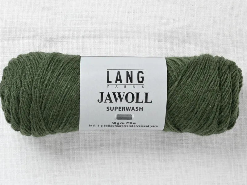 A skein of green Lang Jawoll Superwash lies on light fabric. This 50g/210m fingering yarn is ideal for following the Timo sukka ohje fingerin ja Lang jawoll pattern or your favorite neulontaohje.