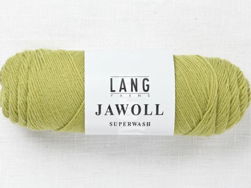 A skein of light green Timo sukka ohje fingerin ja Lang jawoll yarn with a white label rests on a textured white surface—perfect for your next knitting pattern or Timo sukka ohje project.