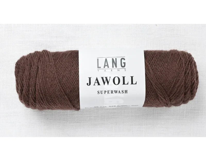 A skein of Timo sukka ohje fingerin ja Lang jawoll yarn with a white LANG YARNS JAWOLL SUPERWASH label, perfect for knitting projects, displayed on a light fabric background.