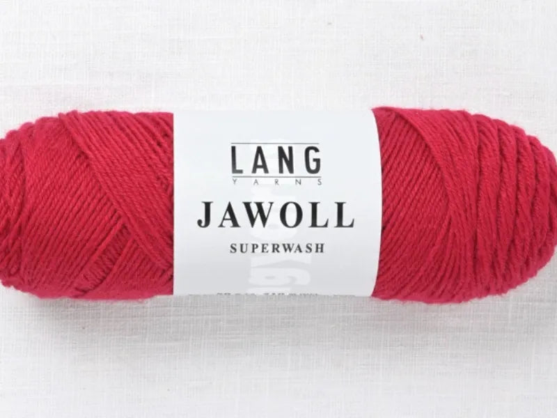 A skein of bright red Timo sukka ohje fingerin ja Lang jawoll yarn with a white label, resting on a light textured surface—ideal for your next knitting or Timo sukka ohje project.