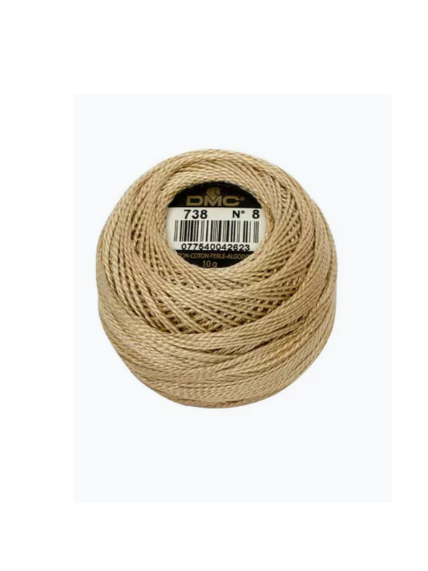 A beige Dmc helmilanka nro 8 embroidery thread, color 738, wound into a neat ball with a black and gold label on top and featuring satiinikiilto (satin sheen).