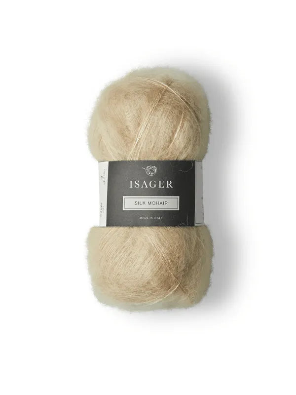 The Cumulus Blouse neuleohje + Isager Silk Mohair features a light beige yarn with a black and white label, ideal for knitting dreamy Cumulus Blouses. Displayed on a white background.