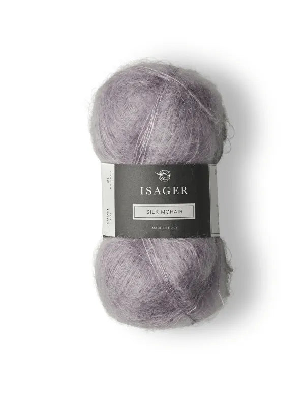 The Cumulus Blouse neuleohje + Isager Silk Mohair features a skein of pale lavender yarn with a black and gray label, ideal for knitting projects, shown on a white background.