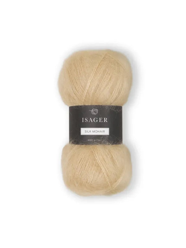 A skein of Isager Silk Mohair in light beige, bundled with the Cumulus Blouse neuleohje, features a black label with brand and product info, displayed on a white background.