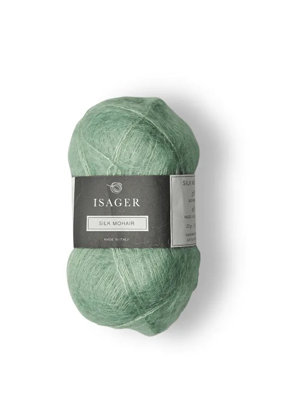 A skein of light green Isager Silk Mohair with a dark gray label is shown on a white background—ideal for your next Cumulus Blouse neuleohje + Isager Silk Mohair project.