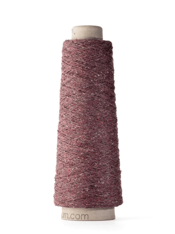 A cone of maroon-colored Ito Kinu, 100% silk with subtle flecks, tightly wound around a cylindrical cardboard spool—perfect for kesäneuleisiin projects.