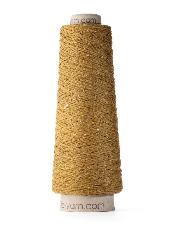 A cone of golden-brown Ito Kinu silk yarn is tightly wound on a cardboard spool, standing upright on a white background. The slightly shiny, textured yarn is perfect for kesäneuleisiin projects.