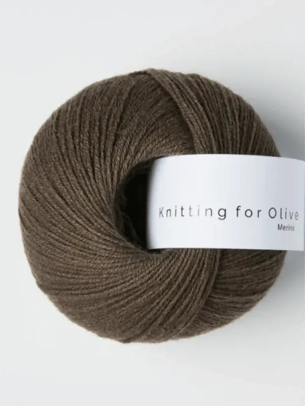 A ball of Knitting for Olive Merino yarn with a white label sits on a light gray background, showcasing its soft merinovillalanka texture and Öko-Tex sertifioitu quality.