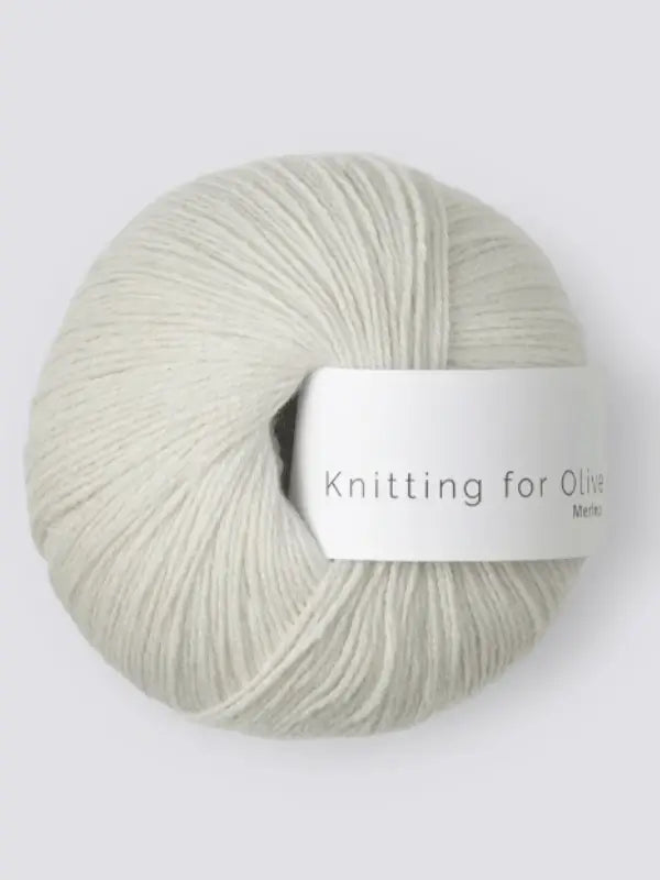 A ball of light grey Knitting for Olive Merino yarn with a white label is shown against a light grey background. This yarn is Öko-Tex certified.