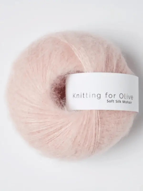 A soft, pale pink ball of Knitting for Olive Soft Silk Mohair yarn with a white label displaying the product name, set against a plain white background.