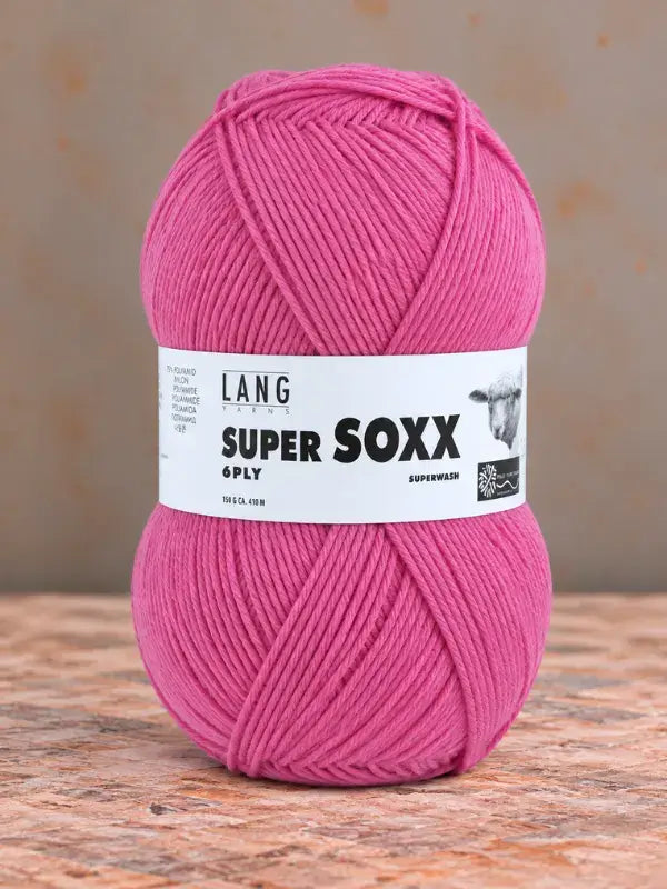 A ball of vibrant pink Lang Yarns Super Soxx 6 ply – kestävä sukkalanka villasta yarn with a white product label featuring a sheep illustration.