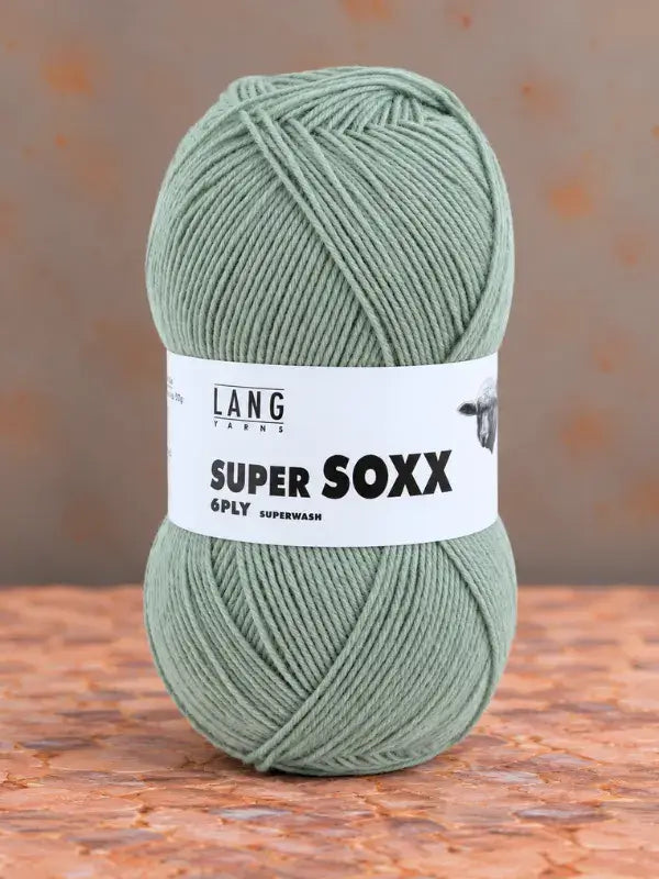 Ball of sage green Lang Yarns Super Soxx 6 ply – kestävä sukkalanka villasta yarn with a product label.