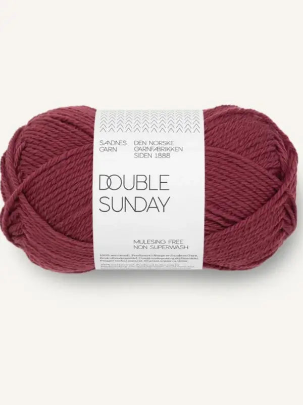 A skein of Sandnes Garn Double Sunday merino wool yarn in dark red, mulesing-free and non-superwash—an ideal choice of neulelanka for your next project.