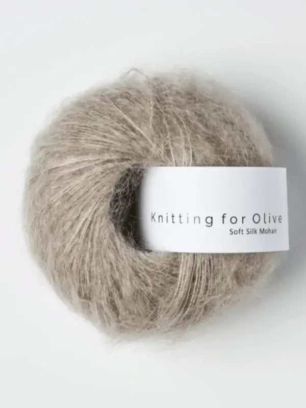 A ball of light brown, fluffy yarn labeled Knitting for Olive Soft Silk Mohair, crafted from luxurious kid mohair and silk fibers, set against a plain white background.