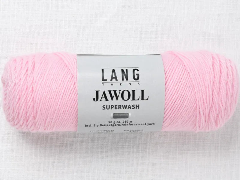 A skein of Timo sukka ohje fingerin ja Lang jawoll light pink yarn lies on a white textured surface, with a label noting 5g of reinforcement yarn and measurements—ideal for neulontaohje or sock knitting projects.