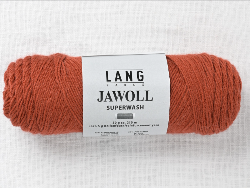 A skein of Lang Jawoll Superwash in rust, featuring a white label on a light textured surface—perfect for cozy creations or using with the Timo sukka ohje fingerin ja Lang jawoll pattern.