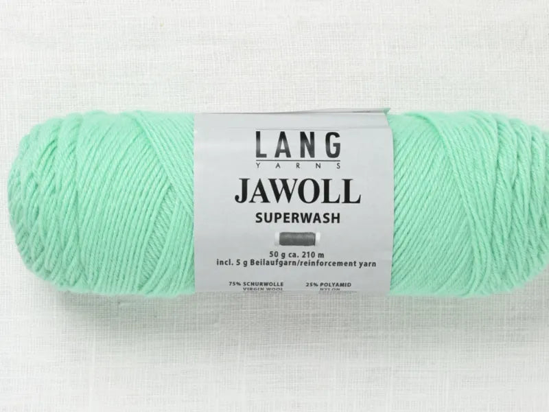 A skein of mint green Timo sukka ohje fingerin ja Lang jawoll yarn with a detailed label on a light textured surface—ideal for your next neulontaohje or handmade sock project.