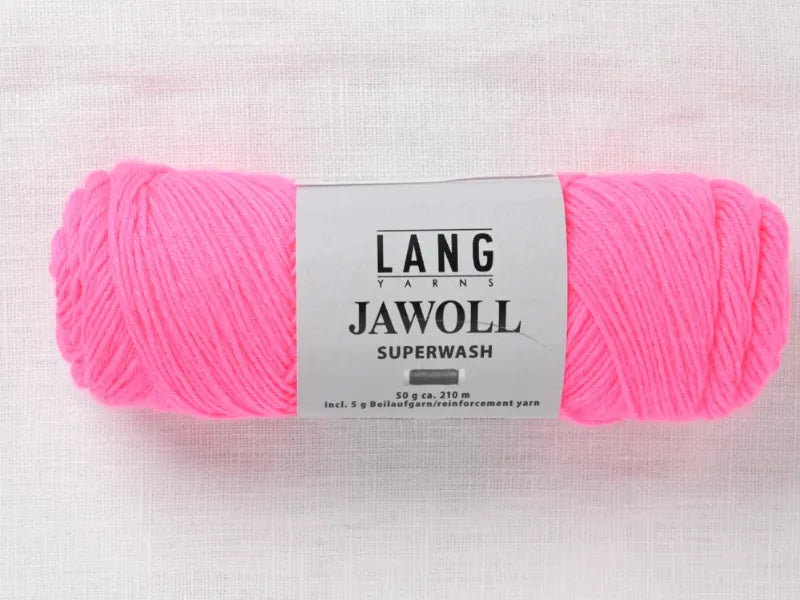 A skein of Timo sukka ohje fingerin ja Lang jawoll yarn in bright pink, ideal for fine projects, rests on a light fabric. The 50g label features care instructions.