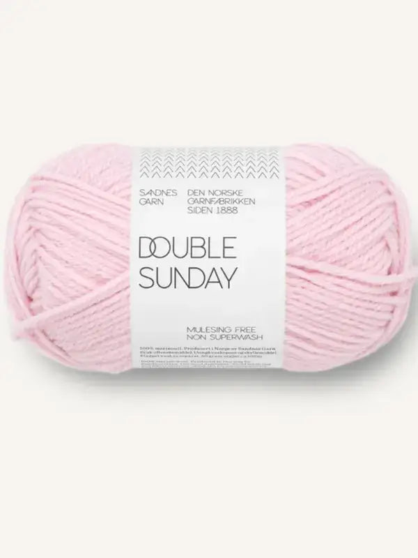A ball of pale pink Sandnes Garn Double Sunday merino wool yarn wrapped in a white paper label.