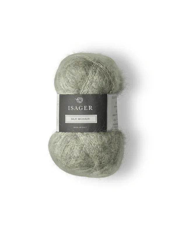 A ball of soft, light green Isager Silk Mohair with a black and gray label sits on a white background—the perfect yarn for your next Cumulus Blouse neuleohje project.