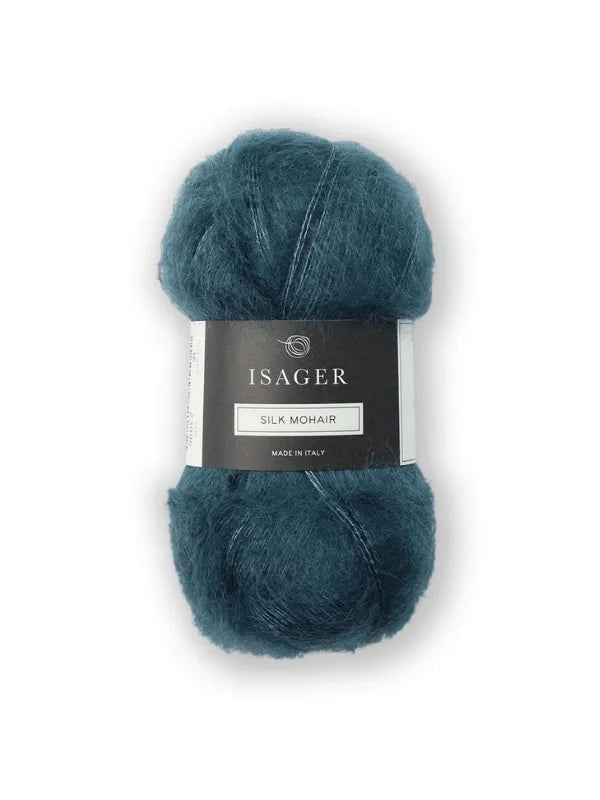 A skein of teal Isager Silk Mohair yarn with a black and white label, made in Italy, is shown for the Cumulus Blouse neuleohje against a white background.
