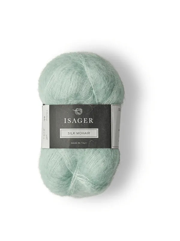 The Cumulus Blouse neuleohje + Isager Silk Mohair features a skein of light green yarn with a black and white label, ideal for your next neule project, displayed on a white background.