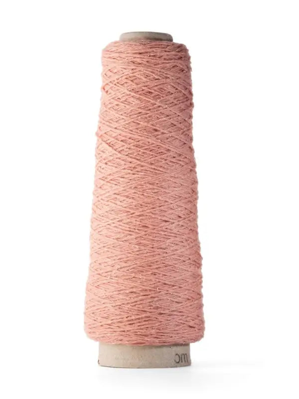 A tall cone of light pink ITO Yarn Shimo stands upright on a white background, tightly wound around a cylindrical cardboard core. This elegant cone features soft merinovilla wool, characteristic of the high quality found in ITO Shimo yarns.