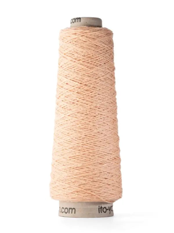 A spool of Ito Yarn Shimo in a light peach color is wound around a cone-shaped cardboard core, standing upright on a white background.
