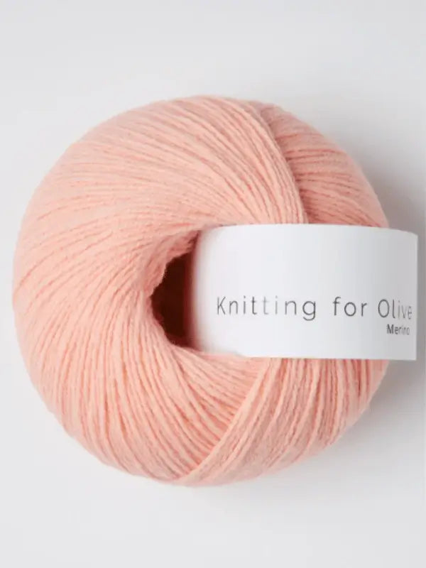 A soft, light pink ball of Knitting for Olive Merino yarn (Öko-Tex certified merino wool) with a white label, displayed on a plain, light background.