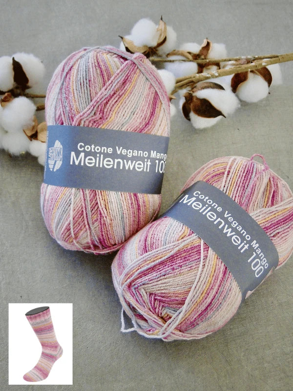 Two skeins of Lana Grossa Meilenweit 100 Cotone Vegano Mango yarn in pink, cream, and yellow rest on a gray surface beside cotton branches. An inset shows a sock knitted from this vegan cotton yarn.