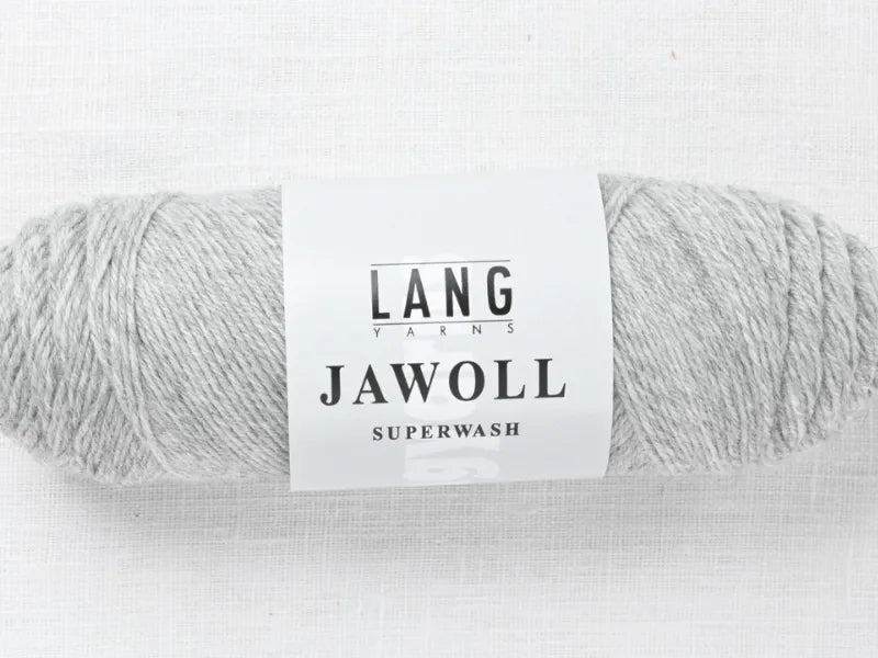 A skein of light gray Timo sukka ohje fingerin ja Lang jawoll yarn with a white label rests on a textured white surface—ideal for neulontaohje or Timo sukka ohje projects.