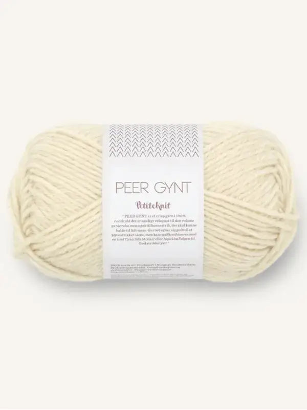 A skein of cream-colored Sandnes Garn Peer Gynt yarn with a paper label featuring a chevron pattern and printed text.