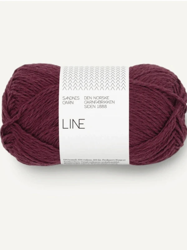 A skein of deep burgundy Sandnes Garn Line yarn for the Milly Sweater & Skirt Neuleohje Suomi, featuring a white band with Norwegian text and a minimalist pattern. Perfect for your next neulesetti project.