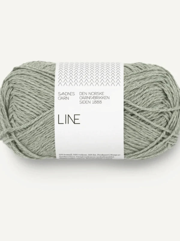A skein of light gray-green Sandnes Garn Line yarn, with a white Norwegian label, is soft and neatly wound—perfect for the Milly Sweater & Skirt Neuleohje Suomi + Sandnes Garn line or your next knitting project.