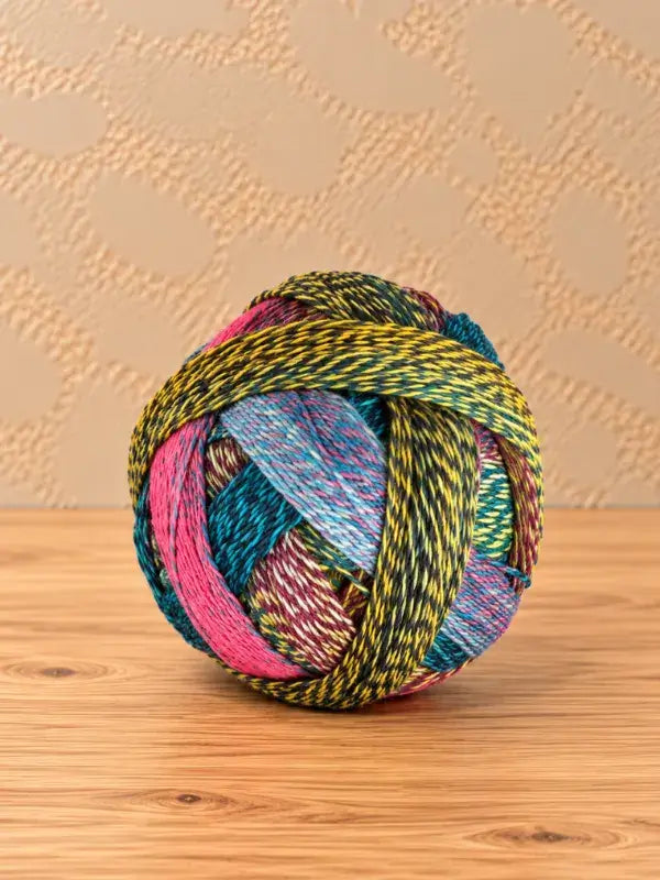 A ball of Schoppel wolle Zauberball crazy multicolored, variegated yarn with black plied strands of superwash-villa.